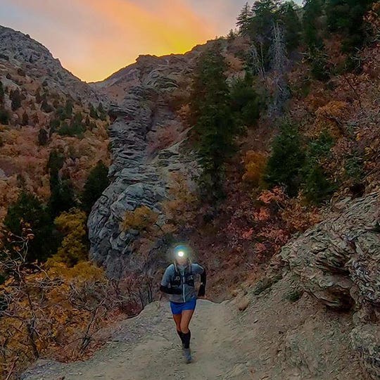 Tara Warren running in the mountains during sunset