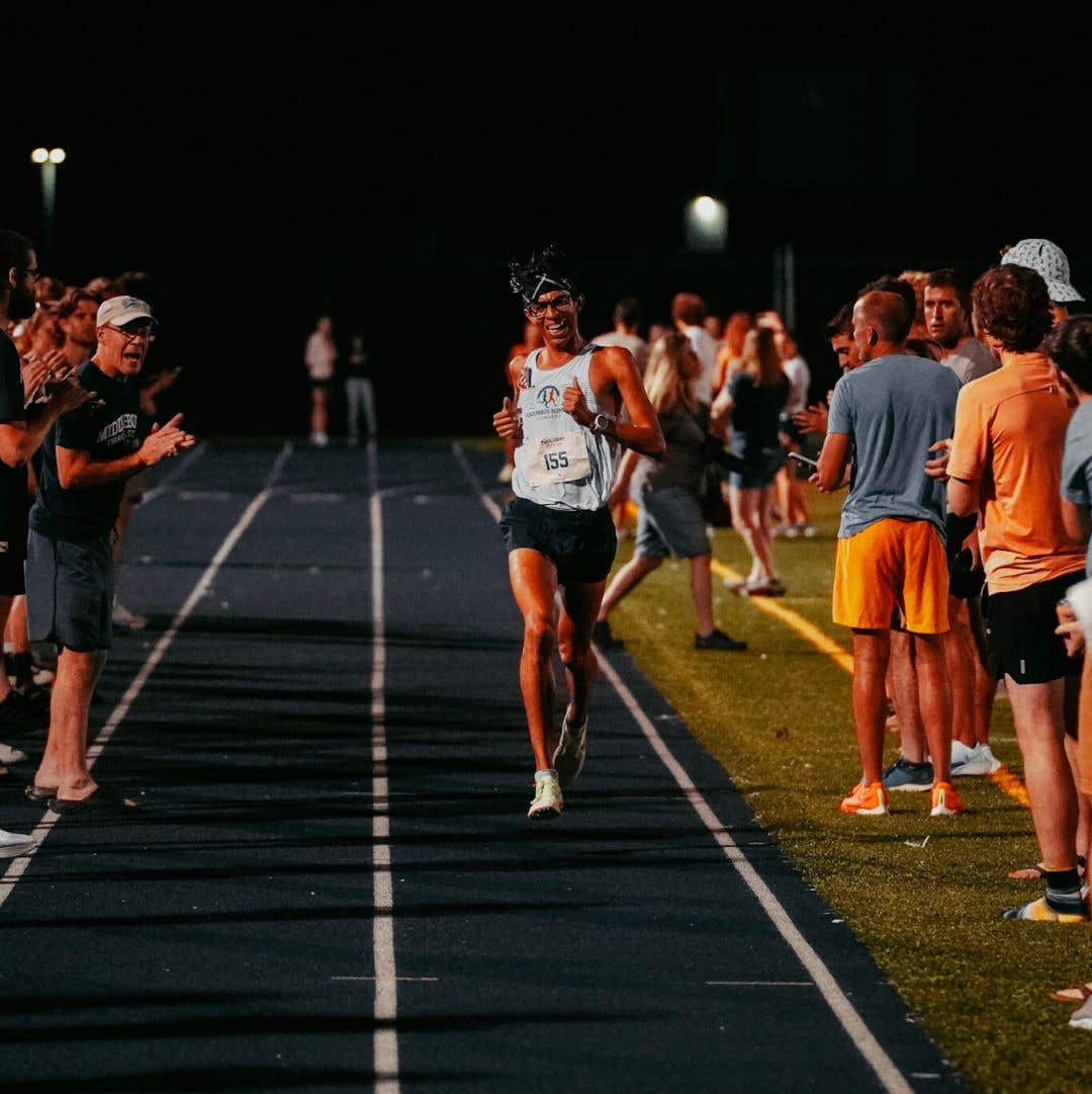 Team Injinji athlete Cris Gutierrez running toward the finish line of a road race.