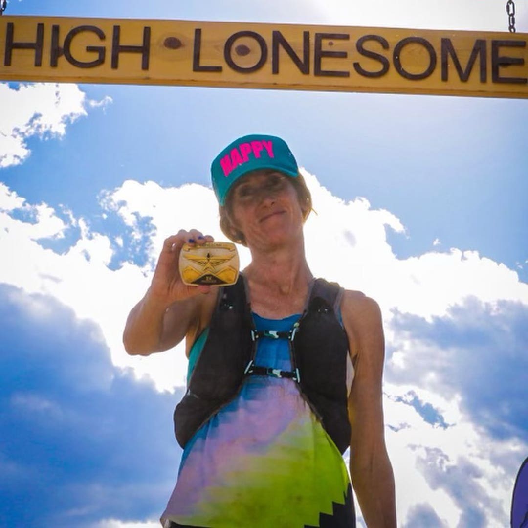 Team Injinji athletes Tara Warren holding up her race medal at High Lonesome 100 and Jessica Storrison-Carmean posing with her race medal at the Grand Island 50k.