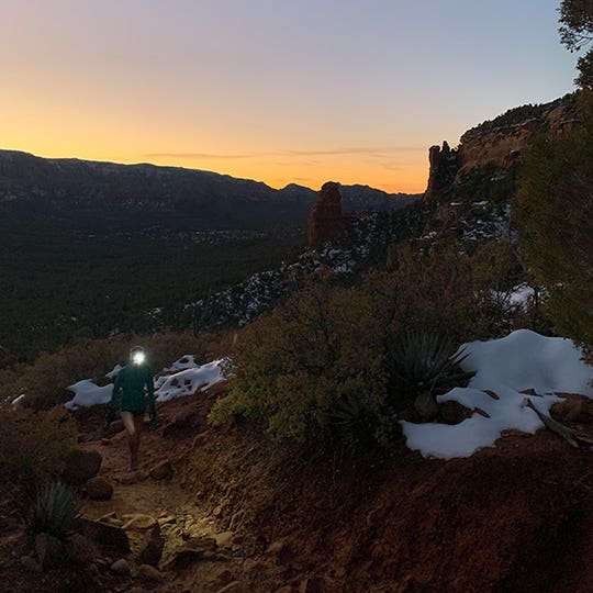 Athlete with a front lamp walking in the mountains in the dark