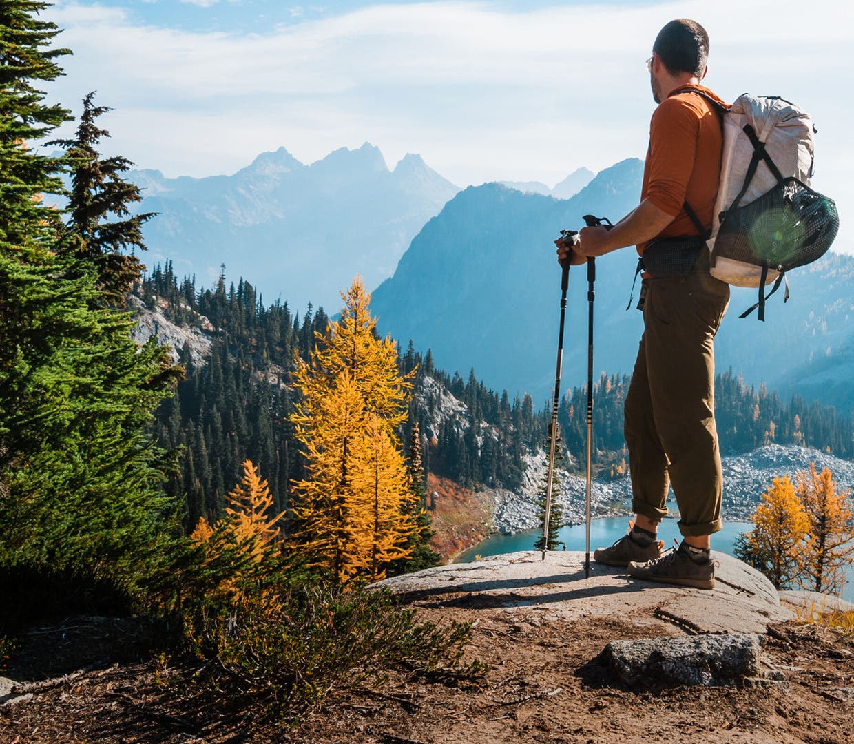 A backpacker looking over an alpine lake wearing Injinji Outdoor Midweight Crew Wool toesocks.