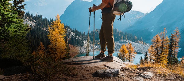 A backpacker looking over an alpine lake wearing Injinji Outdoor Midweight Crew Wool toesocks.