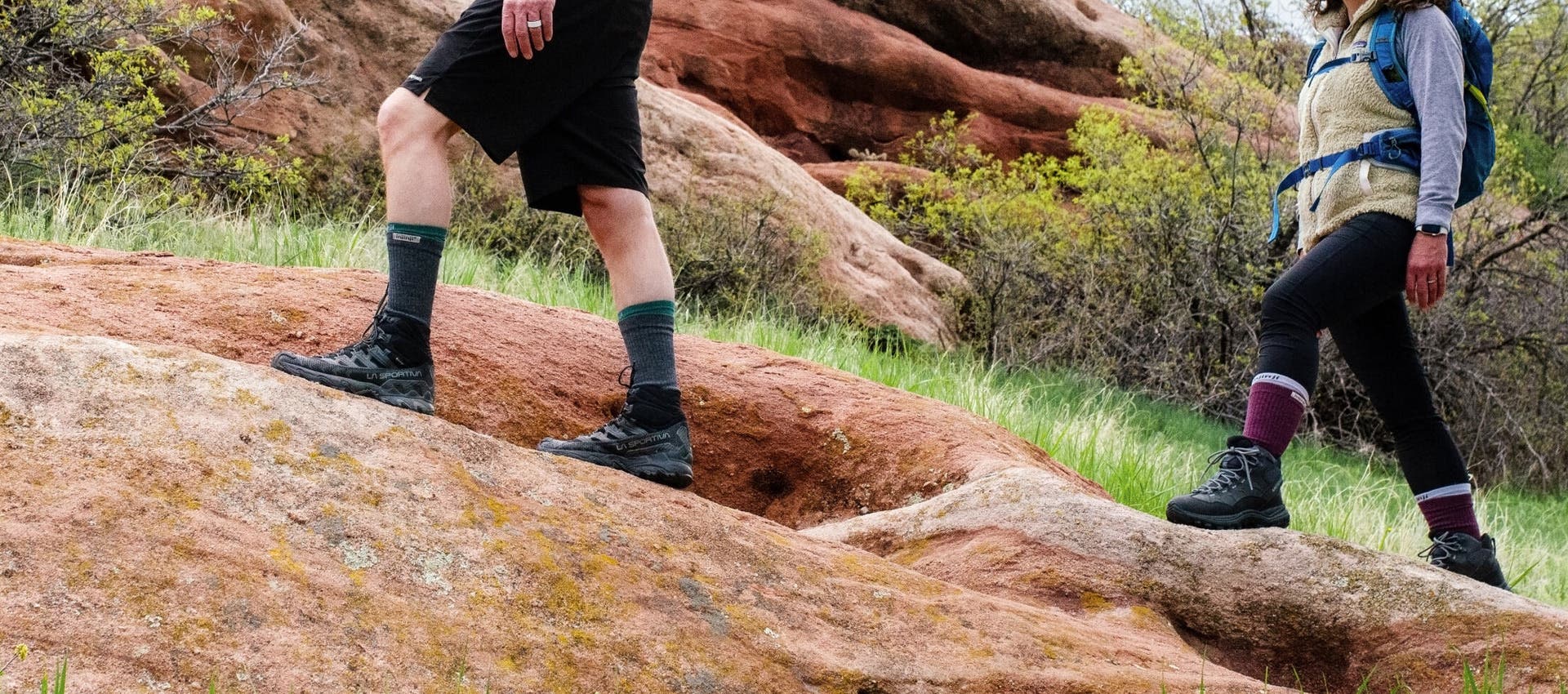 Two people hiking on sand stone rocks wearing Injinji Liner + Hiker Crew toesocks.