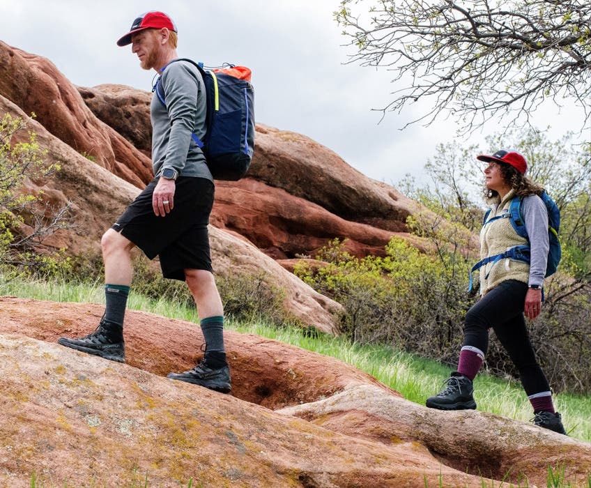 Two people hiking on sand stone rocks wearing Injinji Liner + Hiker Crew toesocks.