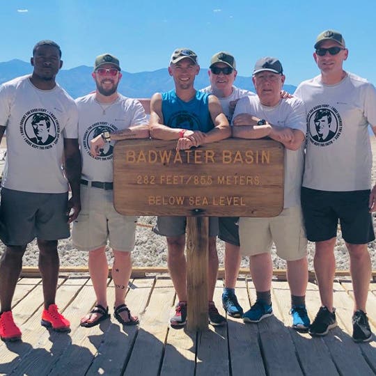 Jonathan Gunderson standing near the "Badwater basin" sign with his five team members