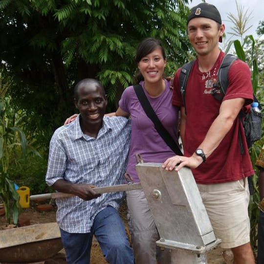 Jonathan Gunderson standing near a man and a woman involved in water wells project