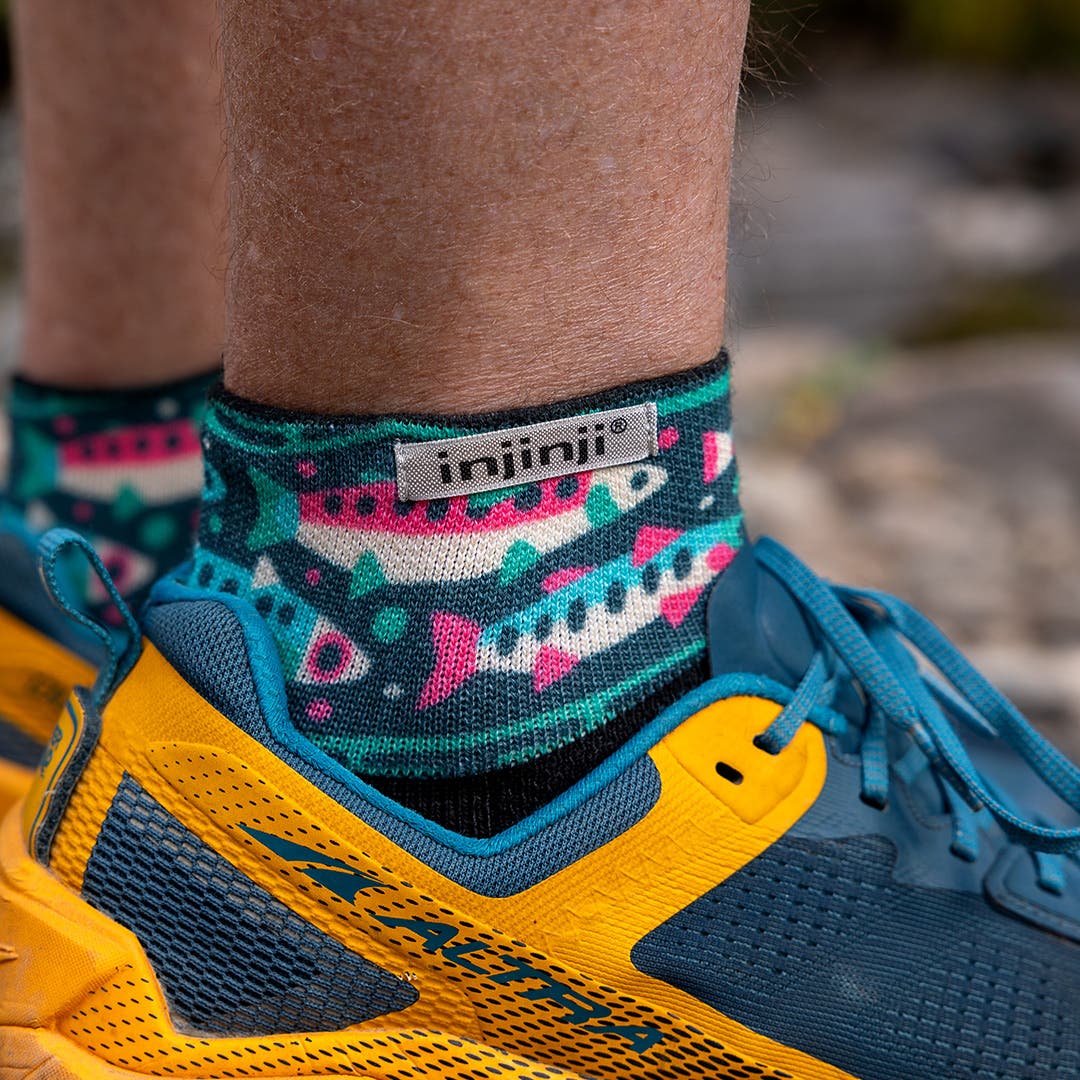 Close up of a person's ankle showing off the Injinji Artist Designed Men's Mini-Crew socks in Trout.