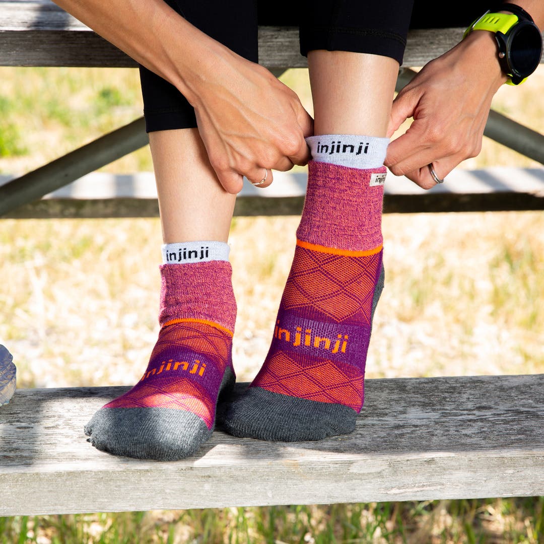 A woman putting on a pair of running socks