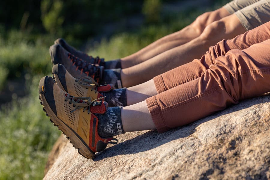 Hikers resting on a rock wearing the Outdoor Midweight Mini-Crew in Merino Wool. 