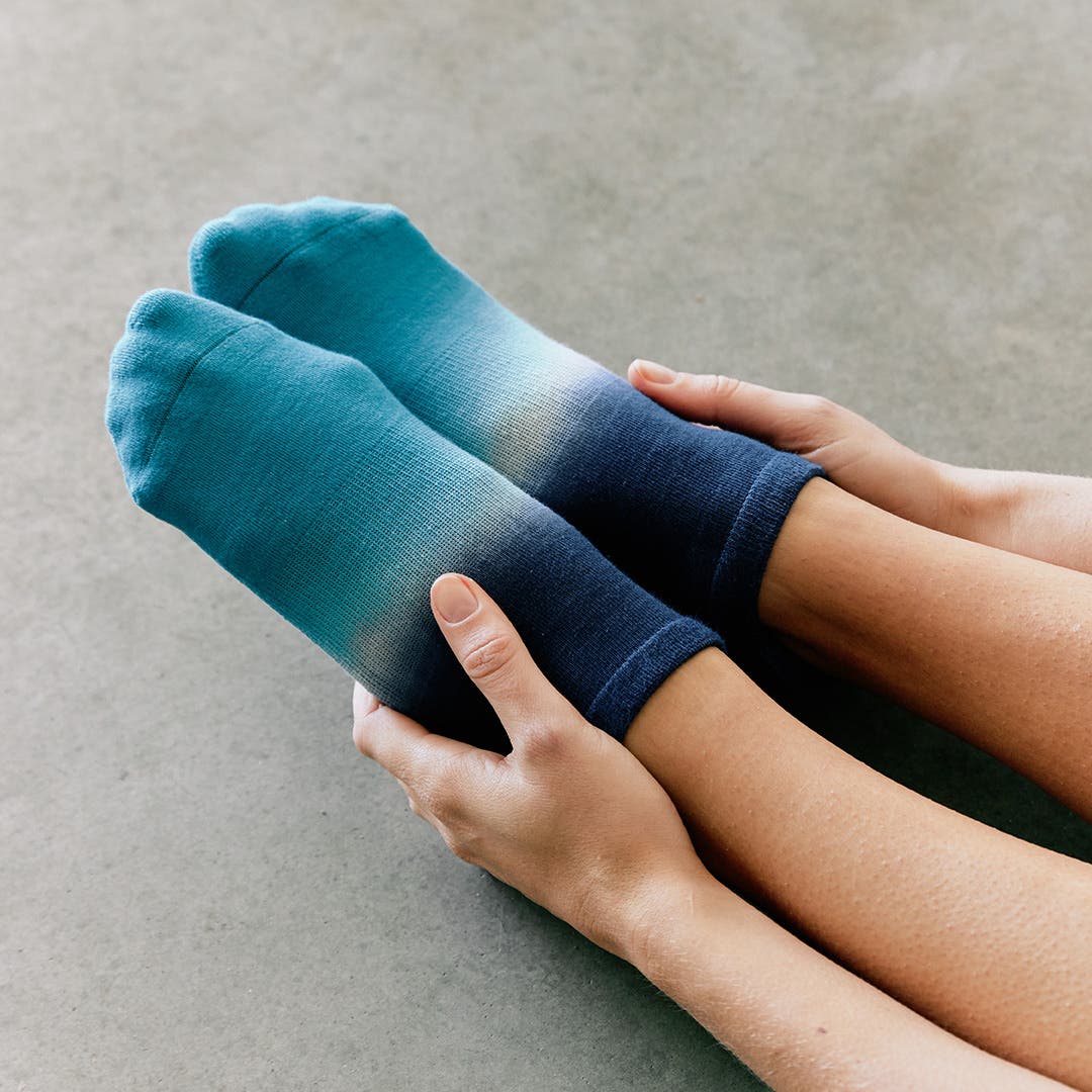 Closeup of a woman's feet wearing Injinji x Pointe Studio Grip Full Foot No-Show socks. 