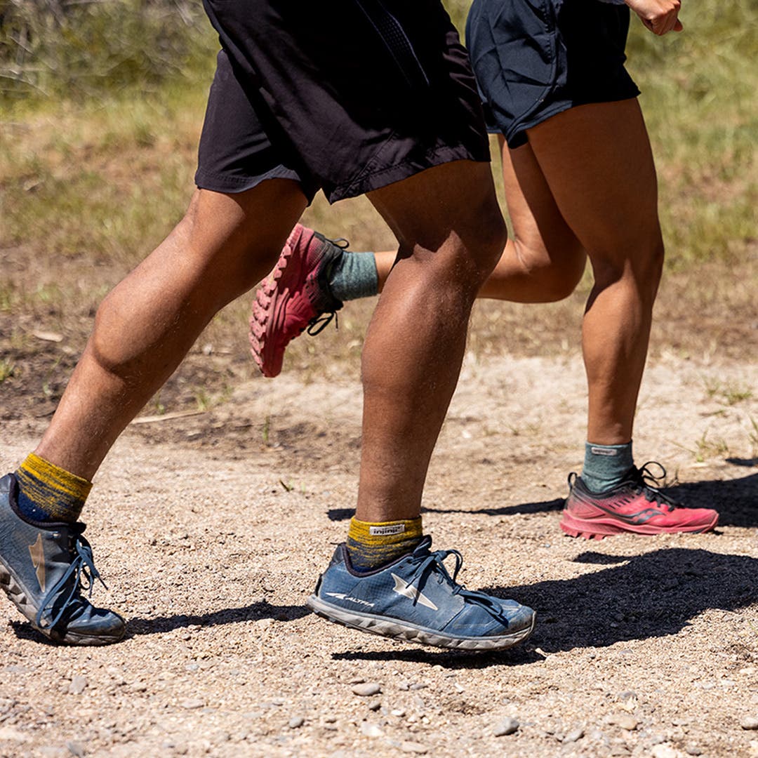Two people running a trail wearing Injinji Trail Midweight Mini-Crew socks in Moonlit and Stargazer.