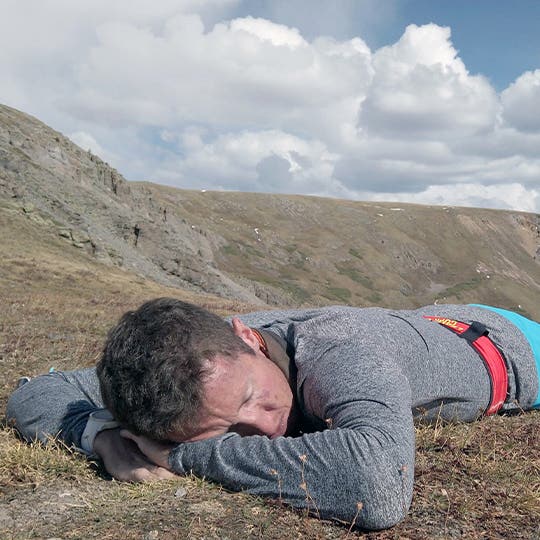 Sleepy Mike McKnight laying on his stomach in the dry grass