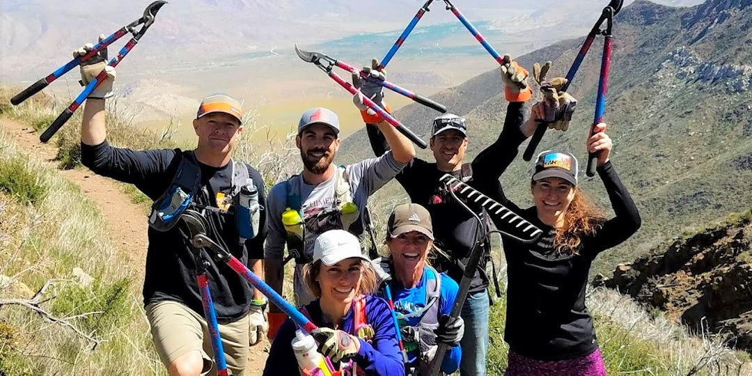 Six participants of the "San Diego Ultra Running Friends" group holding secateurs and a rake in their hands